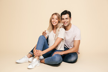 Canvas Print - Portrait of a happy young couple sitting together