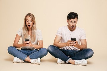 Sticker - Portrait of a shocked young couple sitting together