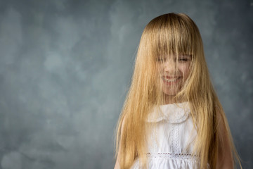 Wall Mural - a little girl with hair combed over her face laughs