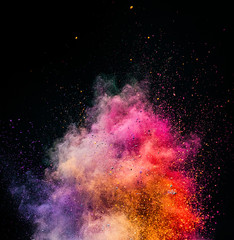 Holi powder exploding on black background.