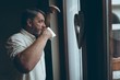 © Wavebreak Media - Senior man having coffee while looking through window at home