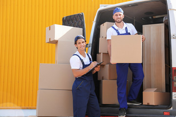 Wall Mural - Male movers unloading boxes from van outdoors