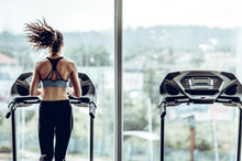 Attractive Woman Running On Treadmill In Sport Gym