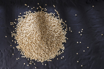 Wall Mural - Quinoa grains with spoon and bowl on black background