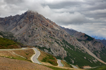 Wall Mural - Xuebaoding, Snow Mountain Pass on the road between Songpan and Huanglong, Sichuan Province China. Sacred Tibetan Mountain, Minshan Mountain Range. High Altitude Mountain Road, Cloudy Summit, Rocks