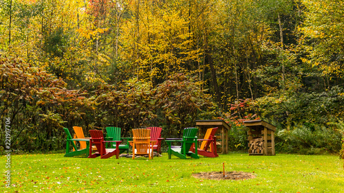 Wooden Adirondack Chairs Arranged In A Circle Around A Fire Pit In