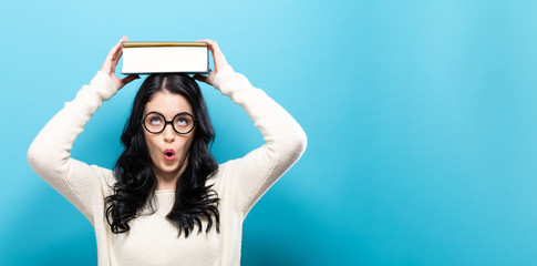 Young woman with a book on a solid background