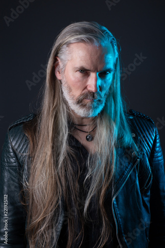 Portrait Of Old Man With Long Gray Hair Leather Jacket And Blue