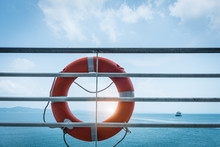 Orange Lifebuoy Ring Hanging On Ferry Boat With Ocean Background