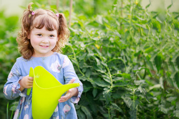 Wall Mural - Adorable girl watering plants in the greenhouse