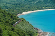 A passenger train passes along lush coastal Vietnam on a beautiful, sunny day