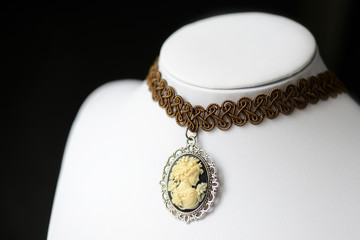 Choker necklace with girl cameo pendant on a dark background close up