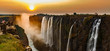 Victoria falls sunset panorama with orange sun and tourists