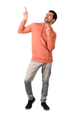 Wall Mural - Full body of  Man in a pink sweatshirt pointing with the index finger a great idea and looking up on isolated white background