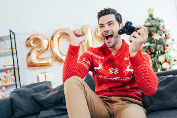 Sticker - excited man playing video game with joystick during christmas