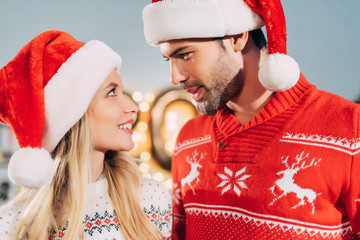 Sticker - happy couple in santa hats looking at each other on christmas eve