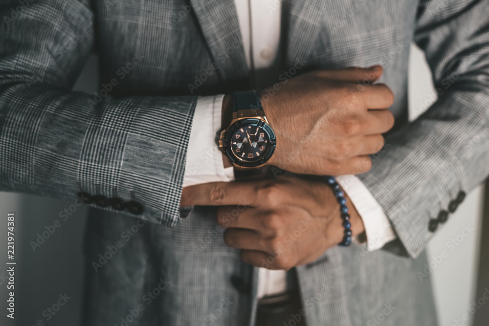 Businessman luxury style. Men style.closeup fashion image of luxury watch on wrist of man.body detail of a business man.Man's hand in a grey shirt with cufflinks in a pants pocket closeup. Toned - obrazy, fototapety, plakaty 