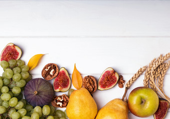 Wall Mural - Autumn fruits, nuts and wheat on the white background, top view