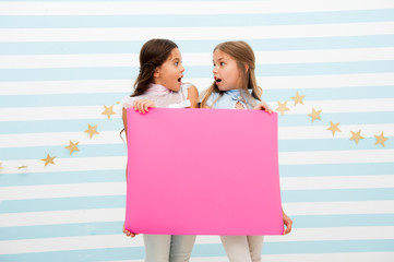 Shocking announcement concept. Amazing surprising news. Girl hold advertising banner. Girls kids holding paper banner for announcement. Shocked surprised children with blank paper copy space