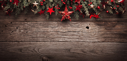 christmas fir tree with decorations and red star on wooden background