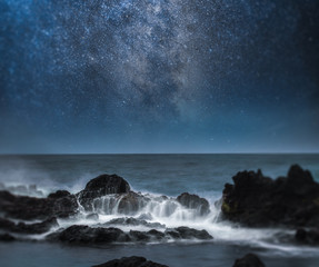 Wall Mural -  a starry night sky over the ocean.