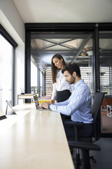 Young businesswoman and businessman working in modern office