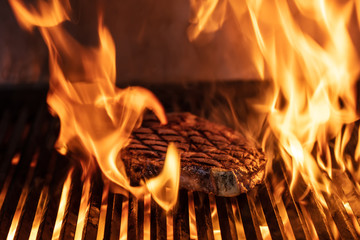 Beef T-bone steaks ( dallas steaks ) on the grill with flames.