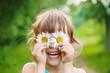 © yanadjan - the girl is holding chamomile flowers in her hands. Selective focus.