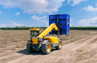 Forklift loader loads plastic containers.