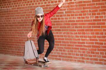 A young hipster girl is riding a skateboard. Girls girlfriends f