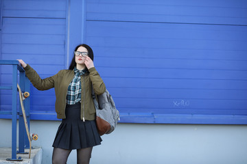 A young hipster girl is riding a skateboard. Girls girlfriends f