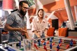 © pantovich - Bearded man with a girl playing table football in a bar
