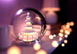 © James Thew - A Christmas tree Snow Globe on top of a fireplace shelf surrounded by fairy lights. 3D Illustration.