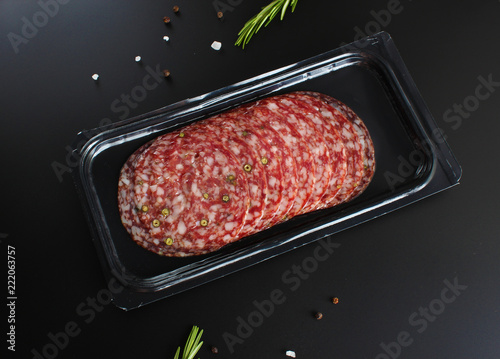 Fotografie, Obraz sausage sliced in a package on a dark background