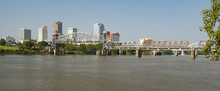 The Arkansas River Flows By The Little Rock Waterfront Under Bridges And Tresles