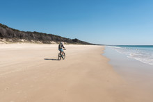 A Female, Baby Boomer, Cyclist On Woorim Beach, Bribie Island, Queensland, Australia.