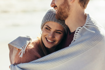 Woman being embraced by her boyfriend at beach