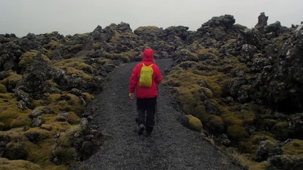dramatic iceland landscape, person hiking on trail, camera following movmement, camera tracking / do