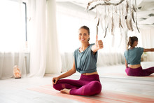Fitness And Healthy Lifestyle Concept - Happy Smiling Woman Showing Thumbs Up At Yoga Studio
