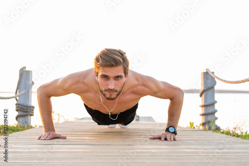 Fotografía Picture of a young athletic man doing push ups outdoors
