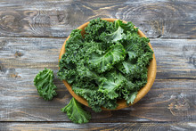 Fresh Green Curly Kale Leaves On A Wooden Table. Selective Focus. Rustic Style. Healthy Vegetarian Food
