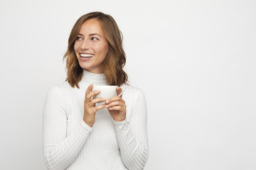 Wall Mural - young woman with cup of coffee looks left