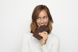 © Martin Villadsen - portrait of young woman biting in a pieace of chocolate looks Left