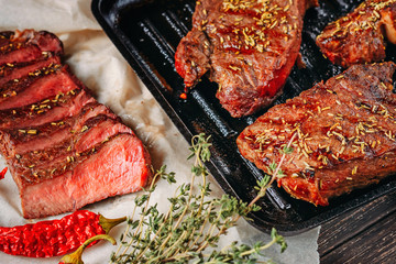 sliced medium rare grilled steak on paper for baking, close up