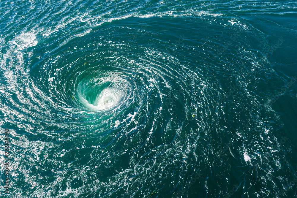 A powerful whirlpool is generated at the surface of the green waters of the river Rance by the action of a turbine of the tidal power station near Saint-Malo in Brittany, France. - obrazy, fototapety, plakaty 