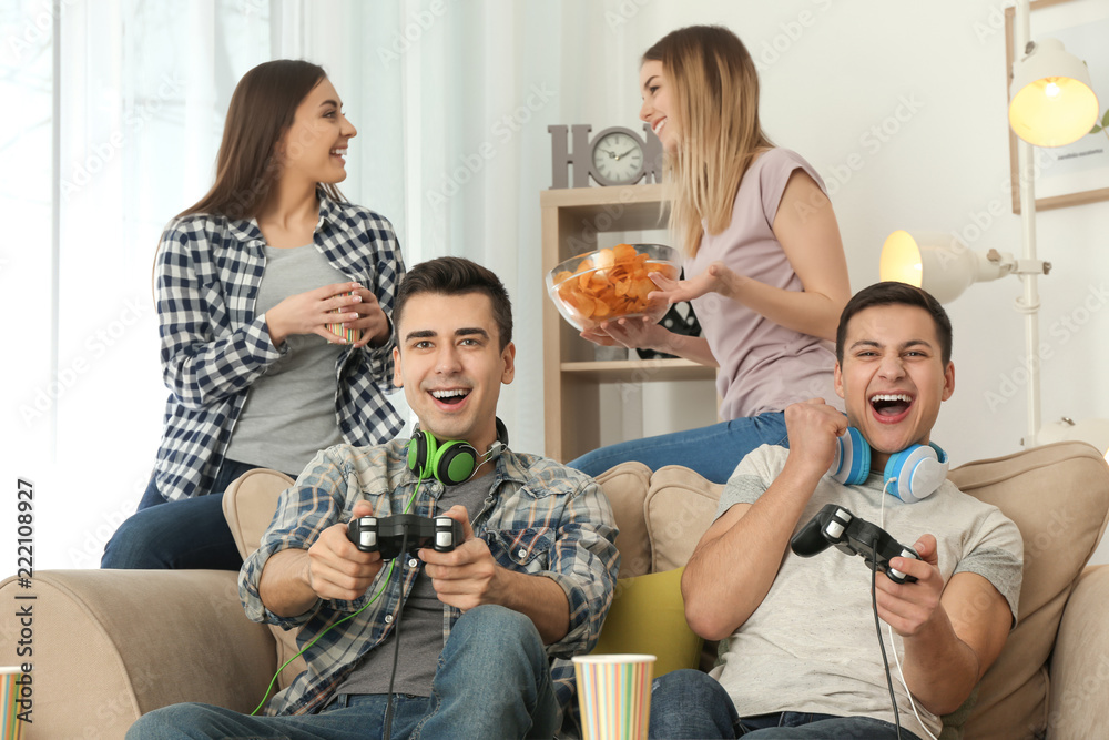 Young people playing video games at home