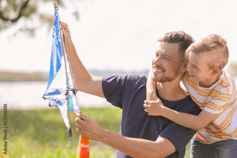 Little boy and his dad with kite outdoors