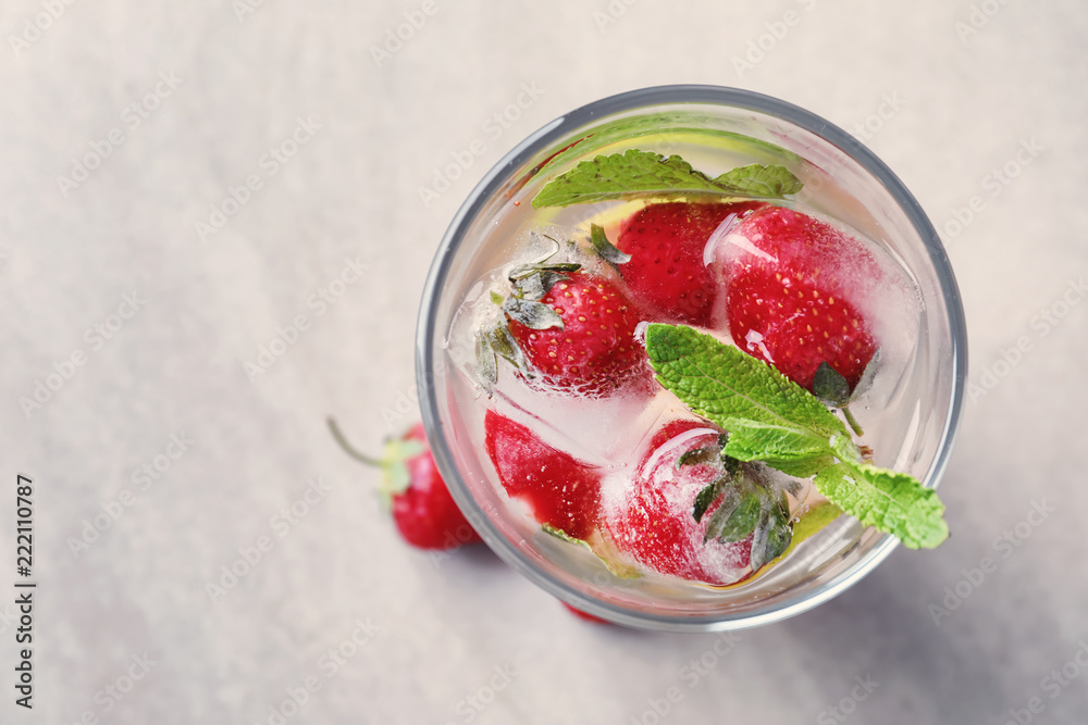 Glass with strawberry mojito on table