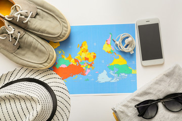 Canvas Print - Composition with world map, mobile phone, clothes and accessories on white background. Travel planning