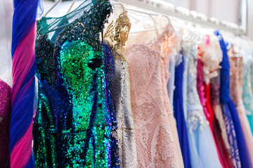 Rack with bright evening dresses.